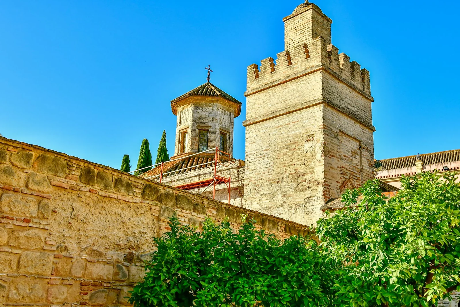Befestigungsturm und Mauern des Alcázars von Jerez de la Frontera vor blauem Himmel