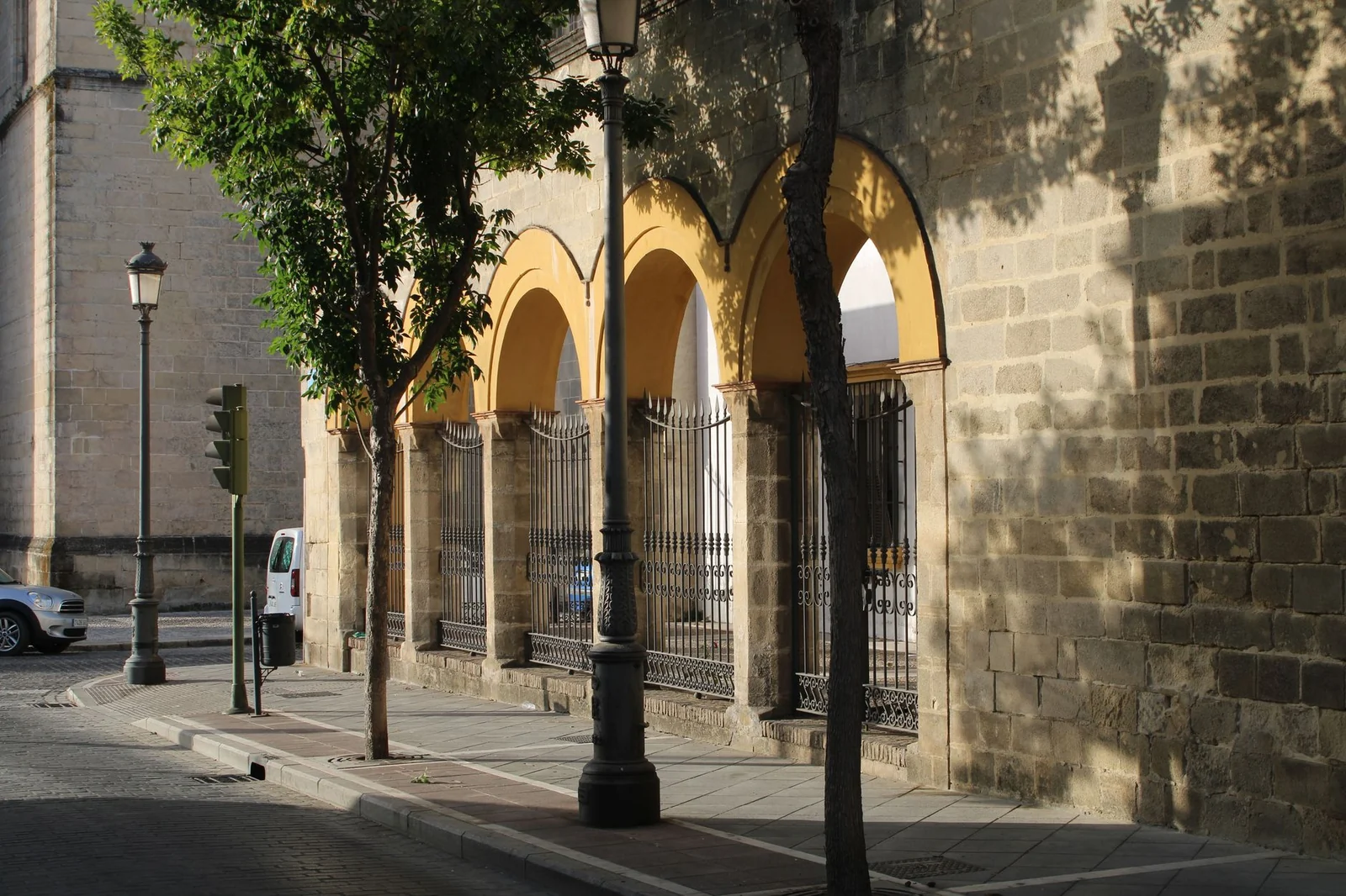Schattige Altstadtstraße mit Arkaden und Natursteinfassaden in Jerez de la Frontera