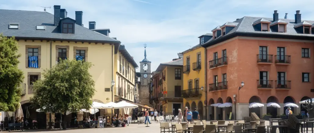 Plaza mit farbigen Fassaden und Uhrturm in der Altstadt von Ponferrada