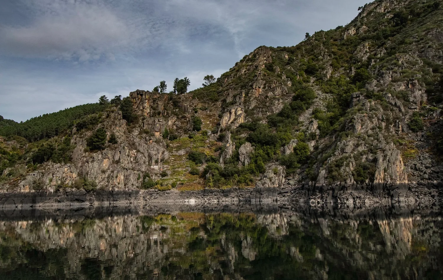 Felsiges Ufer mit Spiegelung im Wasser in der Ribeira Sacra bei Ourense