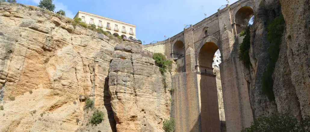 Puente Nuevo über der tiefen Tajo-Schlucht in Ronda mit hellen Felswänden und blauem Himmel
