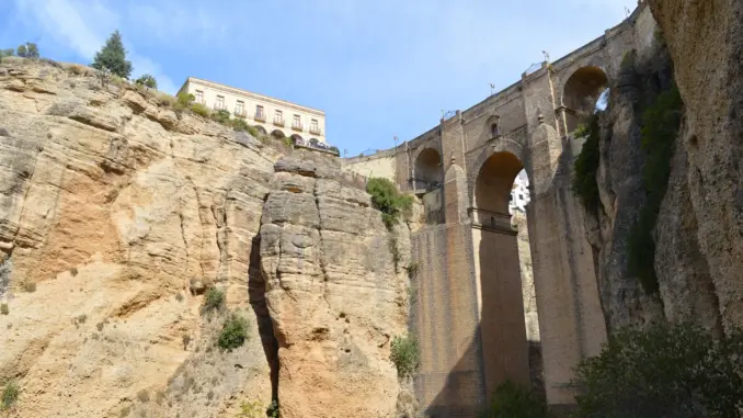 Ronda: Puente Nuevo über der Tajo-Schlucht Puente Nuevo über der tiefen Tajo-Schlucht in Ronda mit hellen Felswänden und blauem Himmel