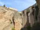 Puente Nuevo über der tiefen Tajo-Schlucht in Ronda mit hellen Felswänden und blauem Himmel